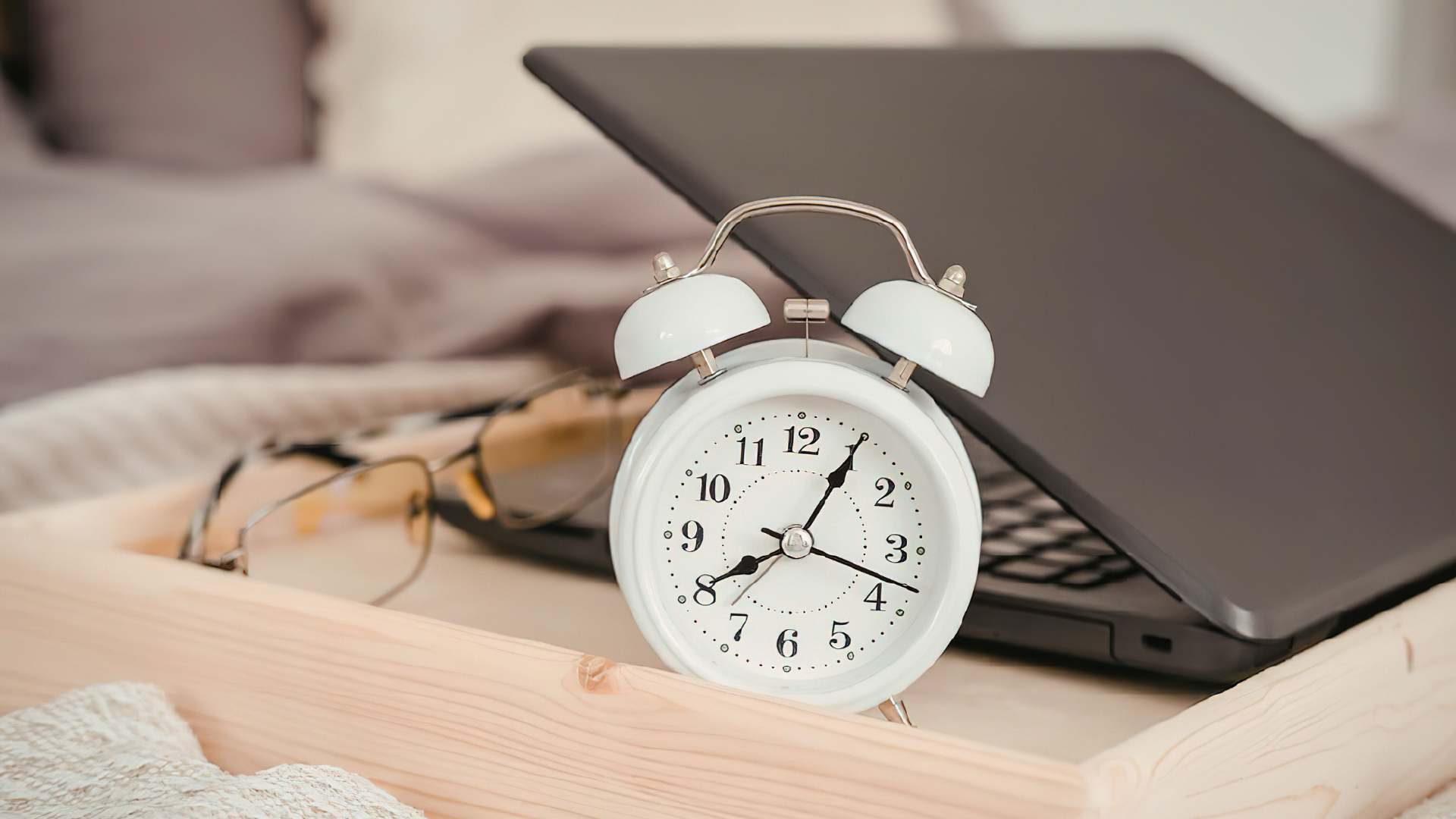 Sveglia, occhiali e computer sul tavolo
